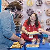 Two smiling people talking at trade show booth