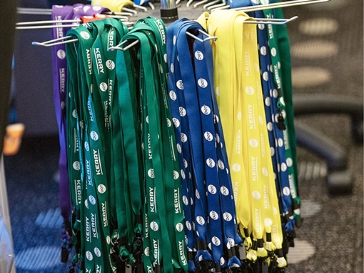 Several multi-colored lanyards showing company logos